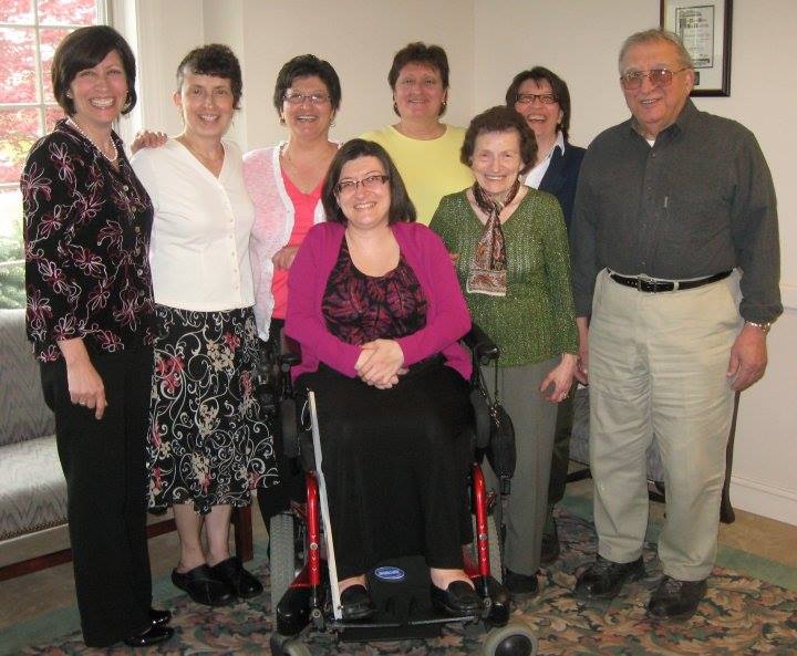 Photo of six white women varying in age and their elderly parents. One of the women, the author, is seated in a wheelchair.